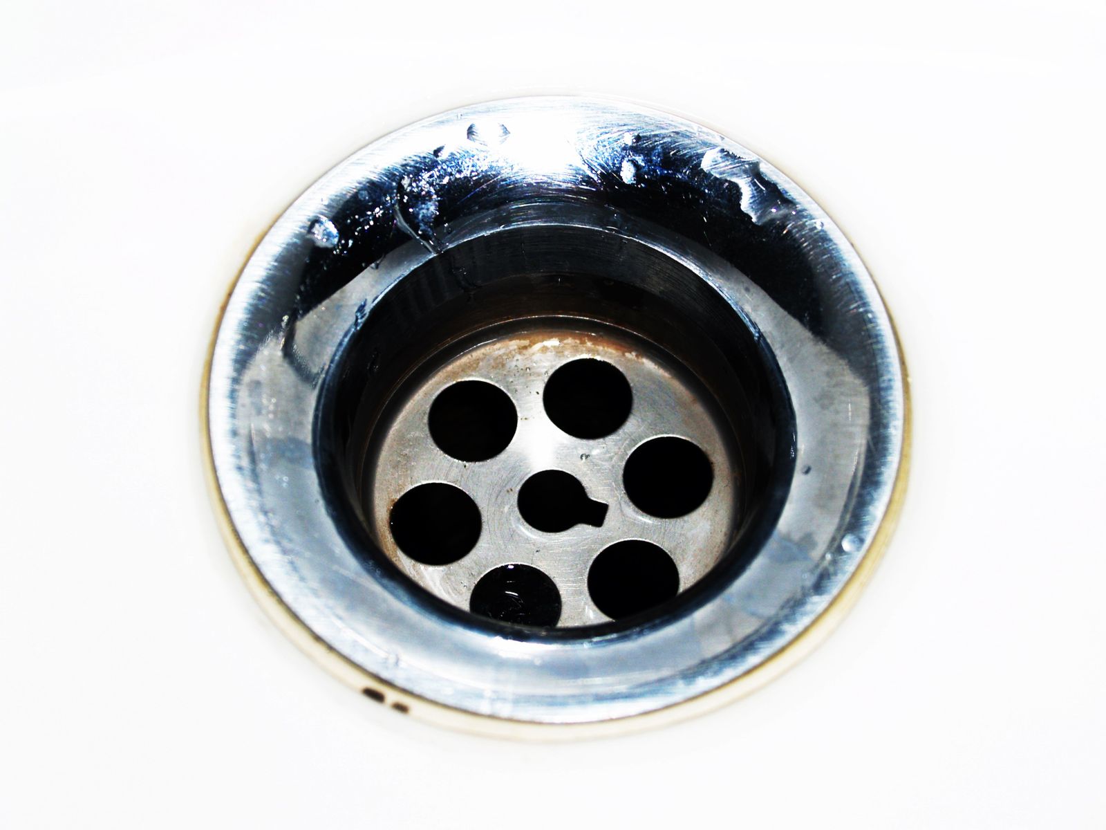 Detailopname van een schoon chromen afvoerputje met waterdruppels