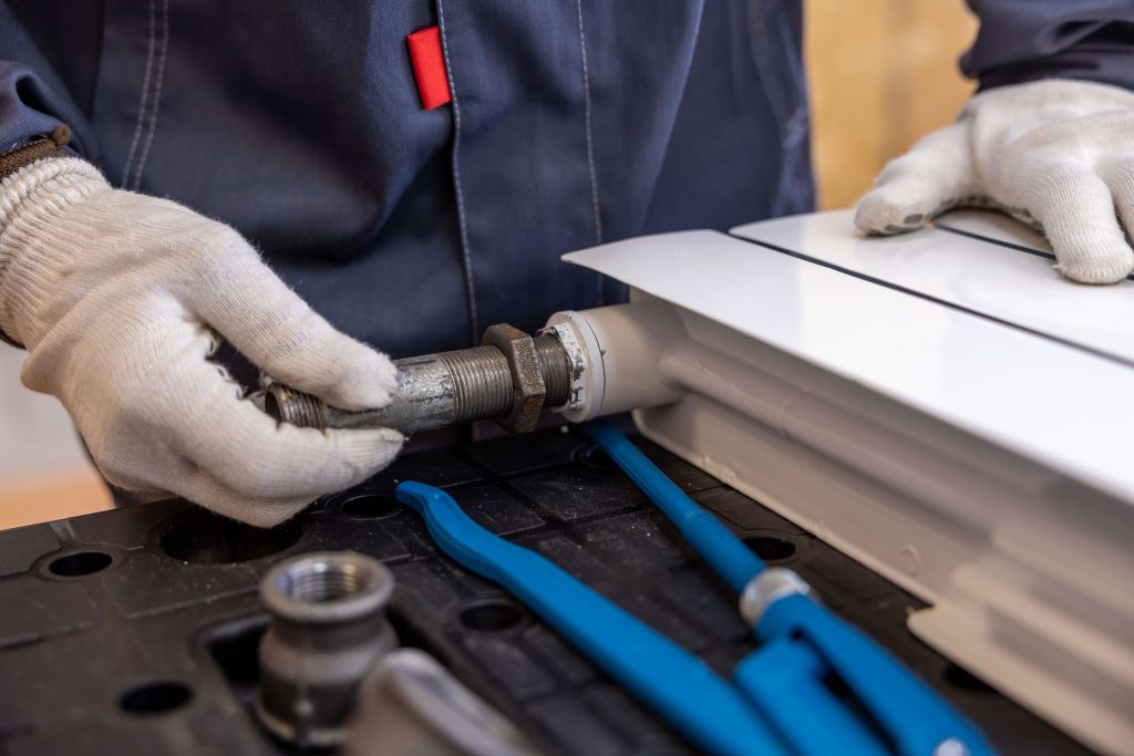 Vakman installeert een verwarmingsleiding met speciaal gereedschap