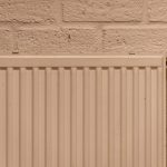 Witte radiator tegen een bakstenen muur in huis