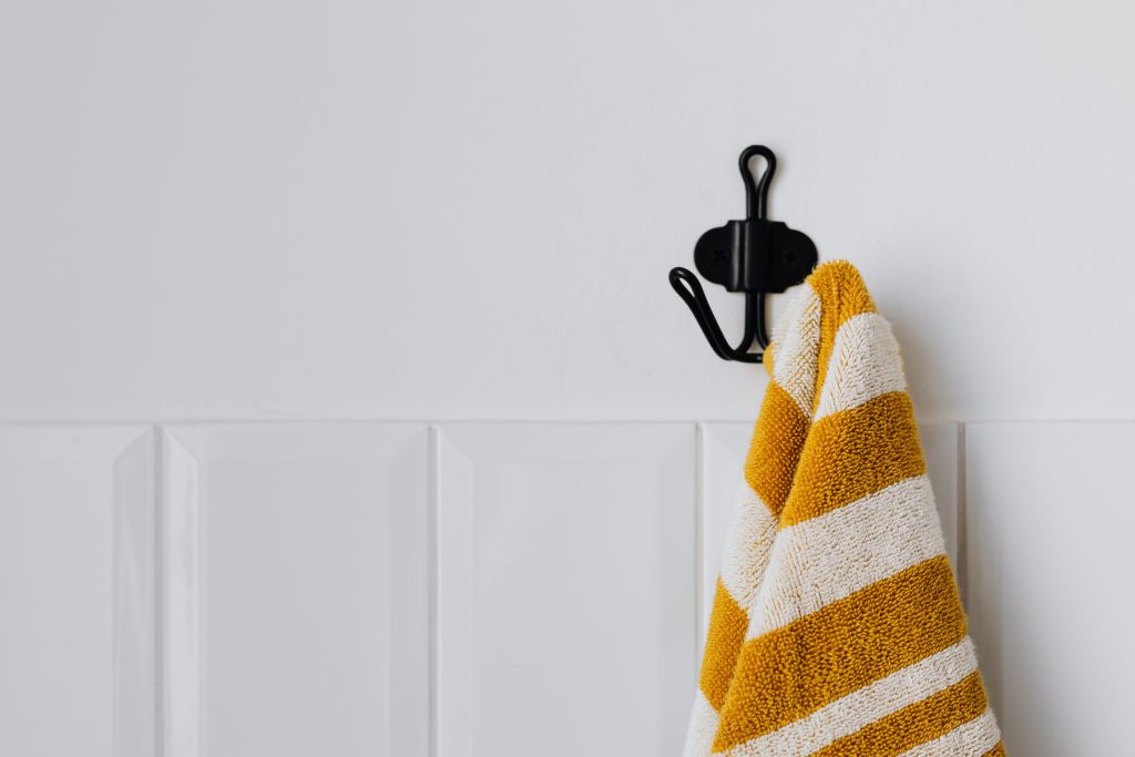 Handdoek hangt aan een moderne haak tegen een muur