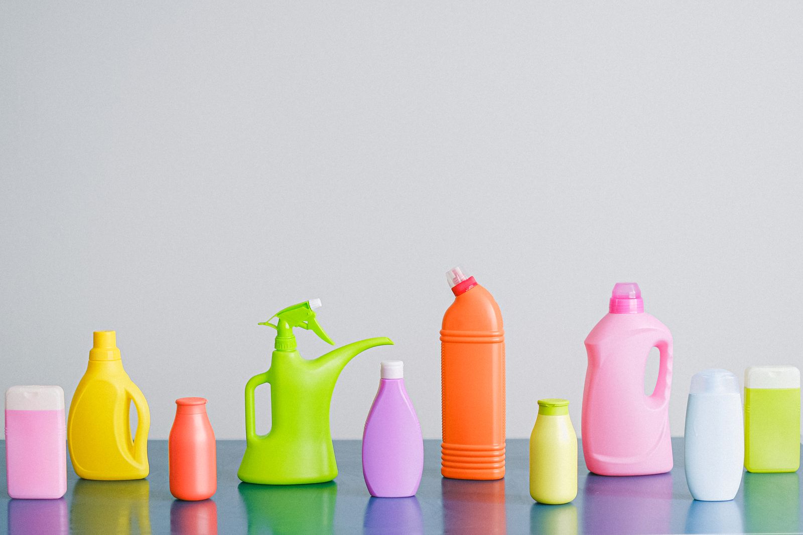 Rij gekleurde plastic flessen met schoonmaakmiddelen op tafel