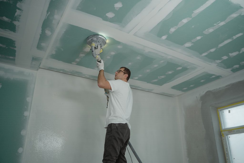 Vakman brengt pleisterwerk aan op een nieuw plafond