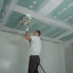 Vakman brengt pleisterwerk aan op een nieuw plafond