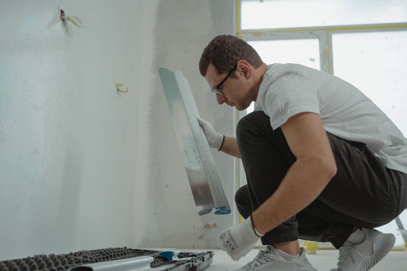 Man werkt met een metalen spaan tijdens een verbouwing