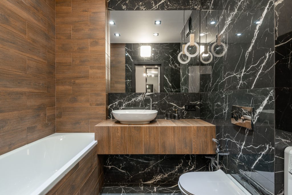 Moderne badkamer met sfeervolle plafondverlichting boven bad en wastafel
