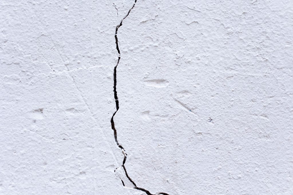 Pleisterwand met een duidelijk zichtbare scheur in het midden