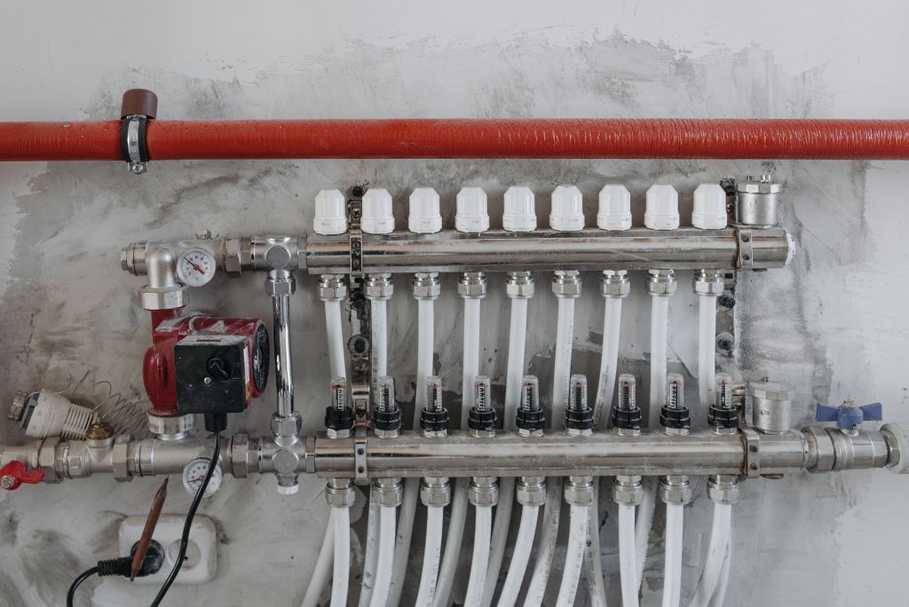 Vloerverwarmingsverdeler met drukmeters en meerdere aangesloten leidingen