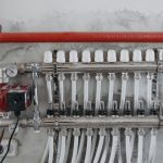 Vloerverwarmingsverdeler met drukmeters en meerdere aangesloten leidingen