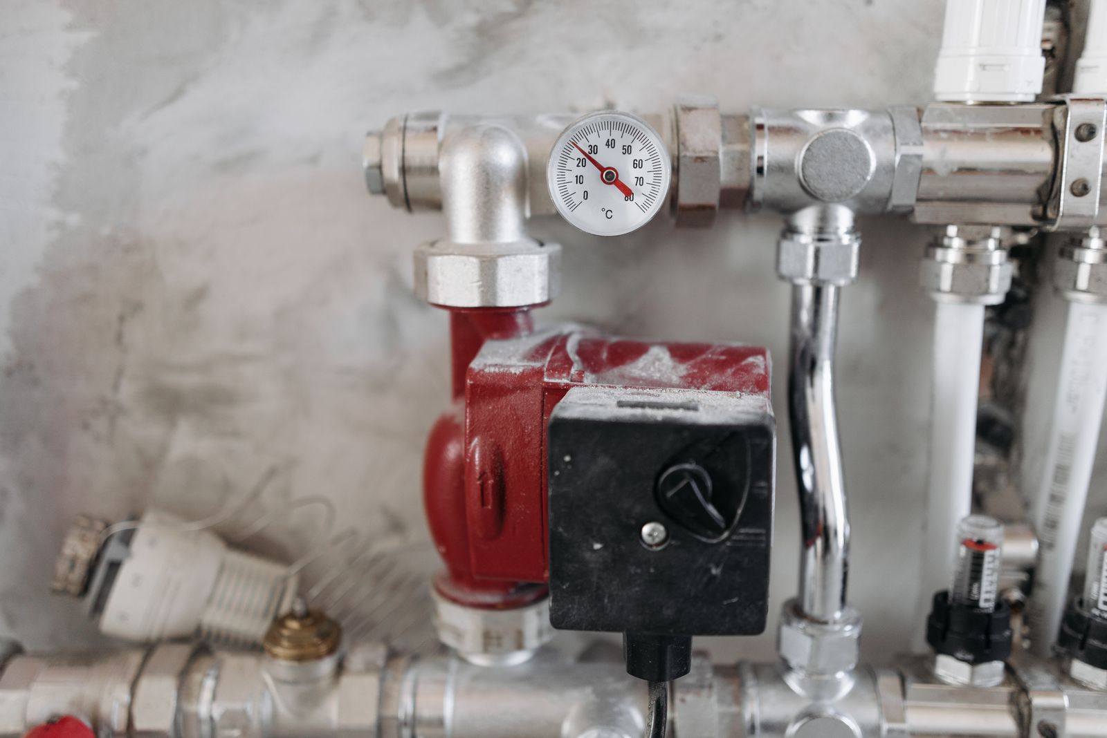 Drukmeter van de verwarmingsketel met aangesloten metalen leidingen