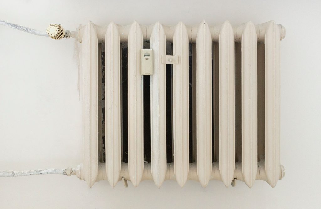 Wit paneelradiator hangt aan een lichte muur