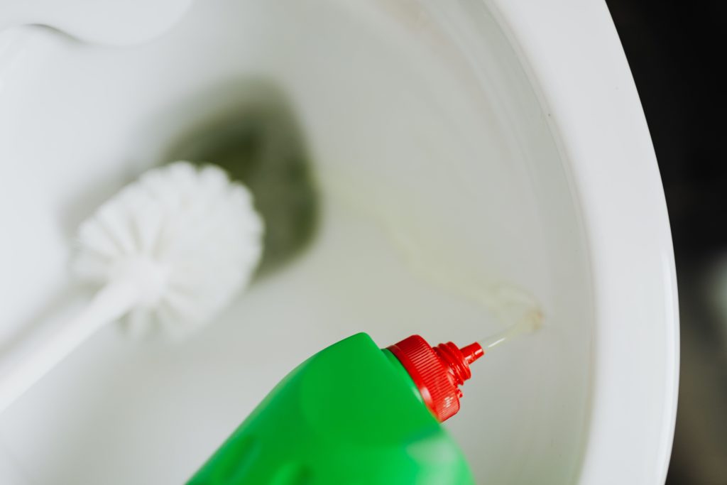 Schoonmaakmiddel wordt in de wc-pot gegoten met borstel